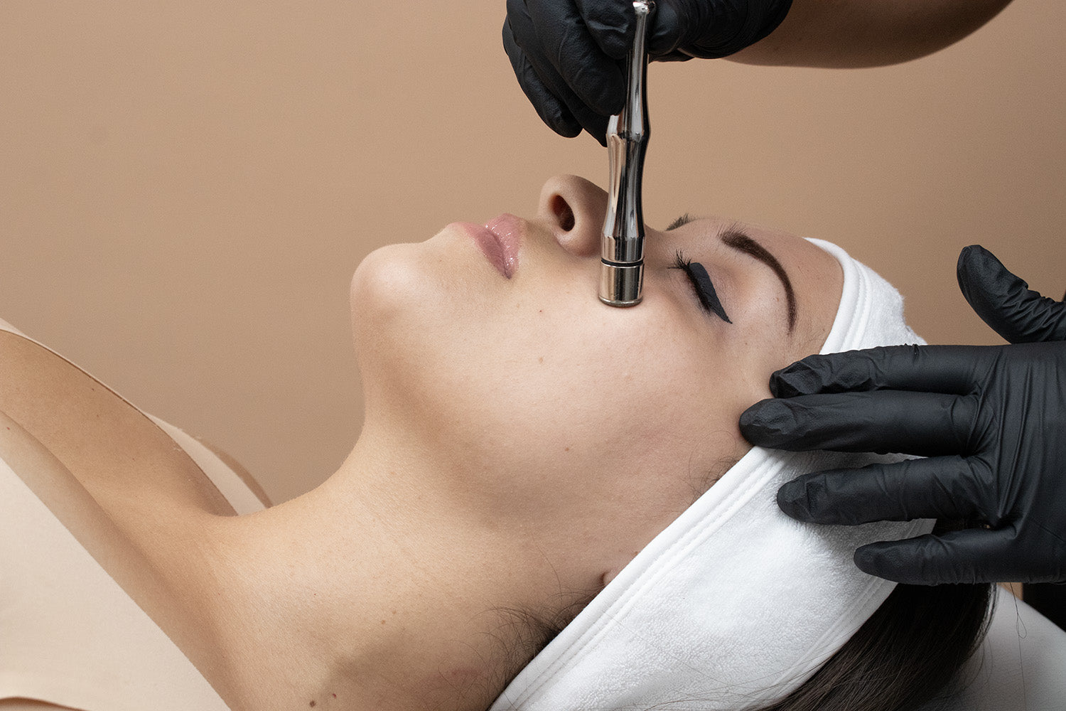 A woman receiving a cosmetic treatment on her face.