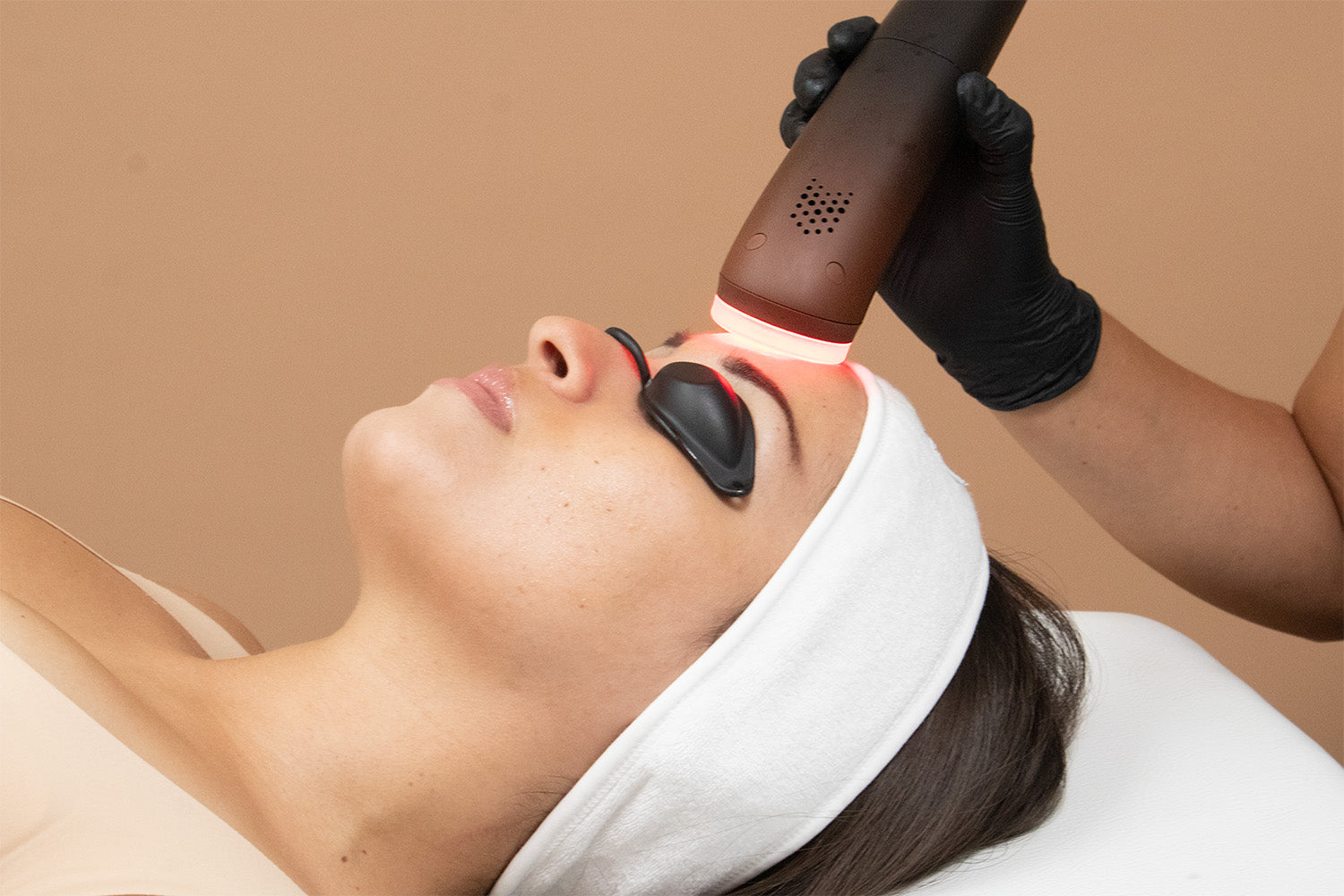 A woman receiving a cosmetic treatment on her face.