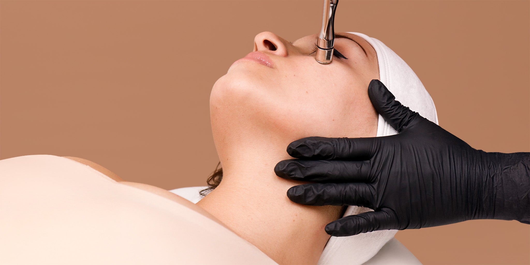 A woman receiving a cosmetic treatment on her face. 