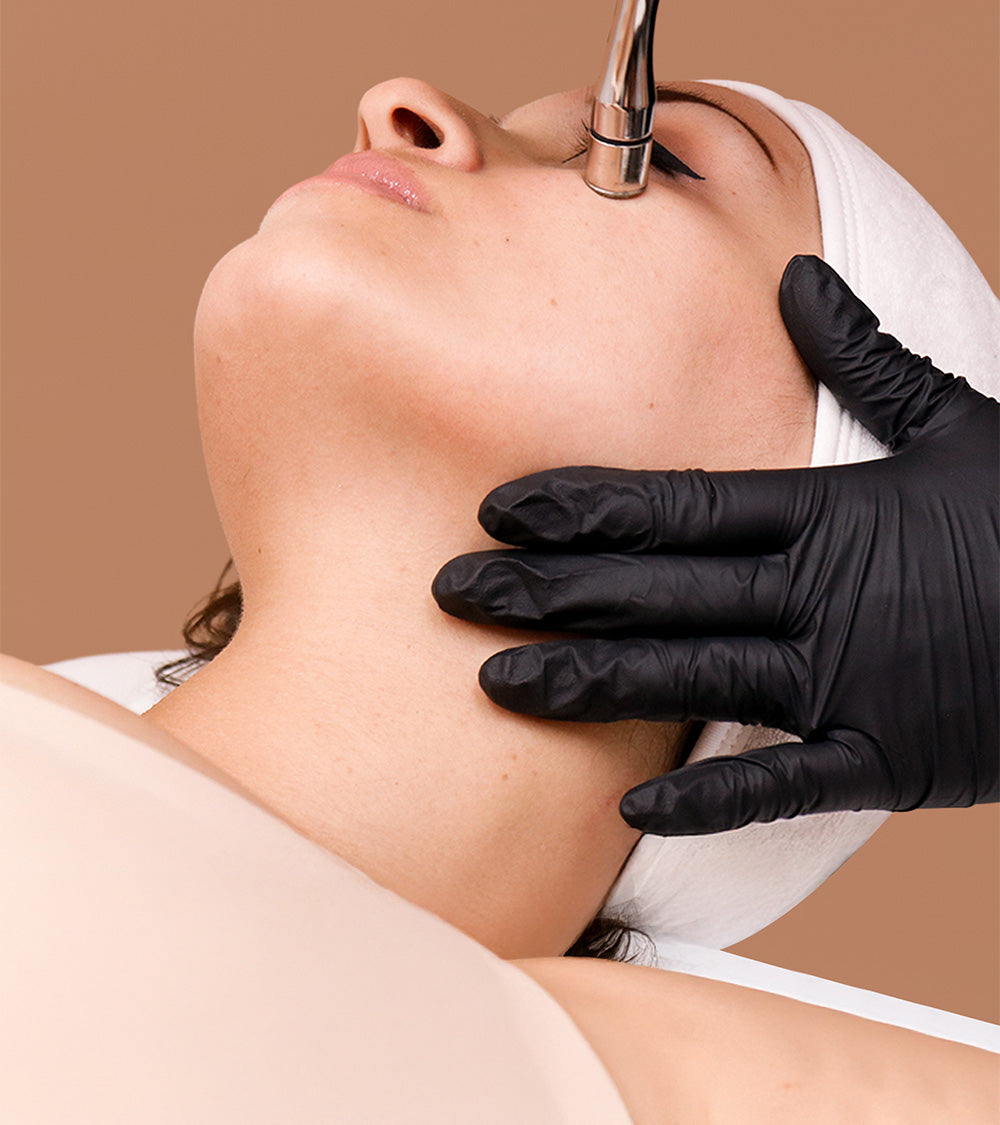 A woman receiving a cosmetic treatment on her face.