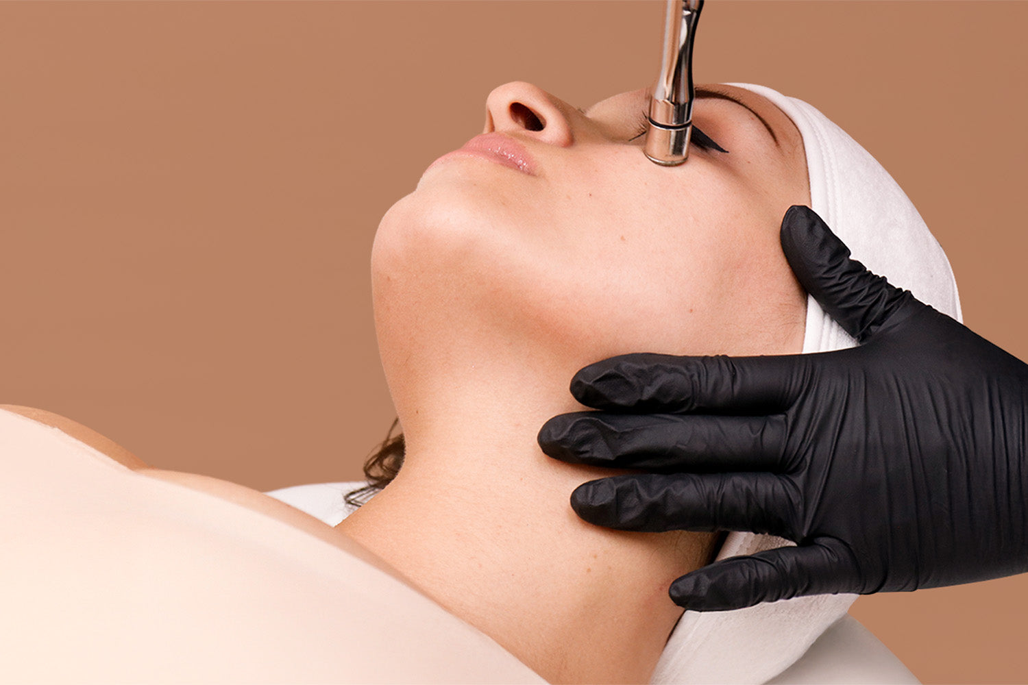 A woman receiving a cosmetic treatment on her face. 