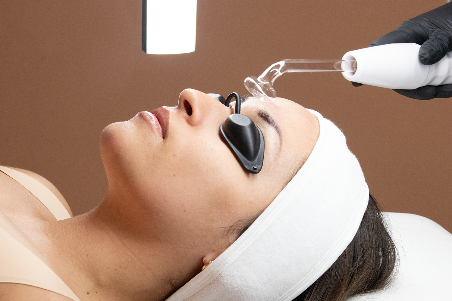 A woman receiving a cosmetic treatment on her face.