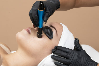 A woman receiving a cosmetic treatment on her face.